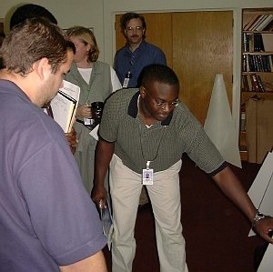 Drew Obeng, a student from University of Central Florida, explains his poster to a judge. Randy Debasa (left), a student from Florida International University, collaborated with Drew on their supercomputing project.